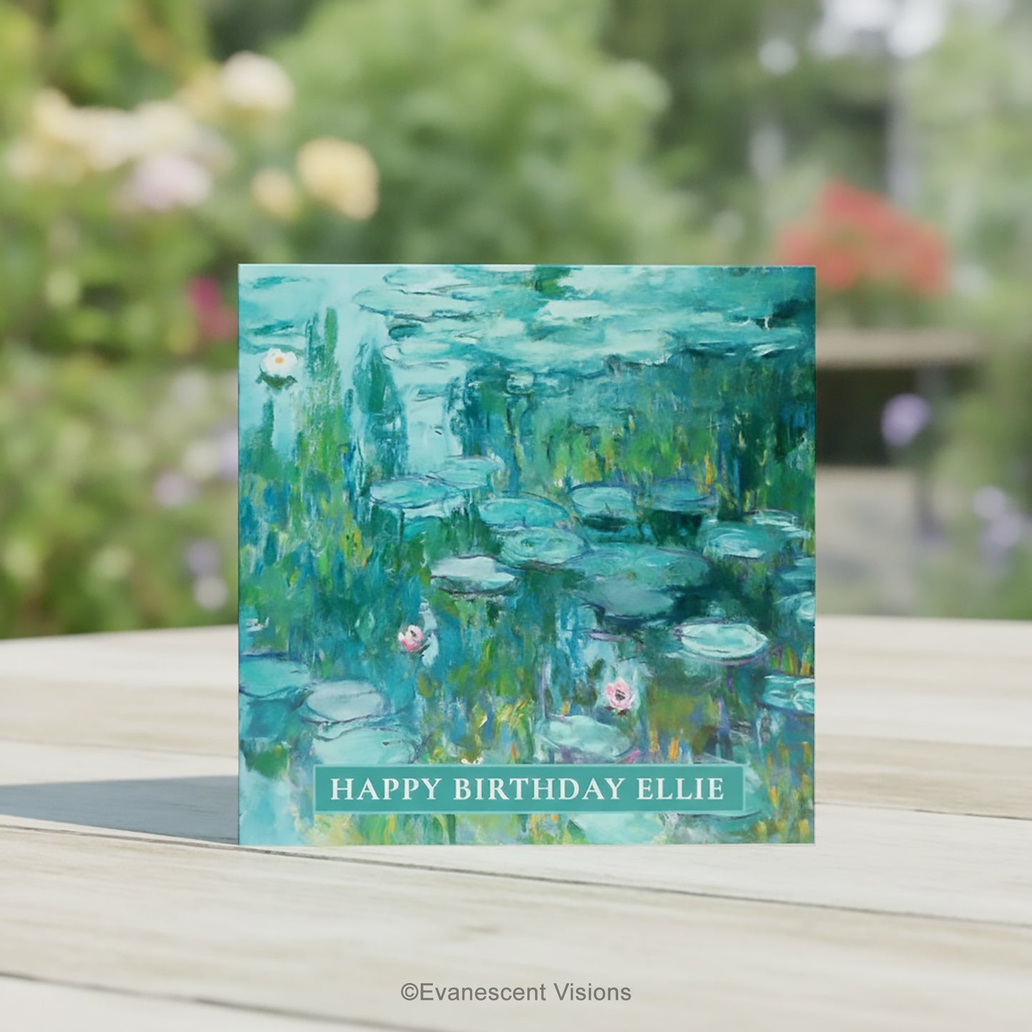 A square greeting card featuring an impressionistic Water Lilies painting by Claude Monet in teal, green, and blue tones with pink water lilies, on a table in a garden.
