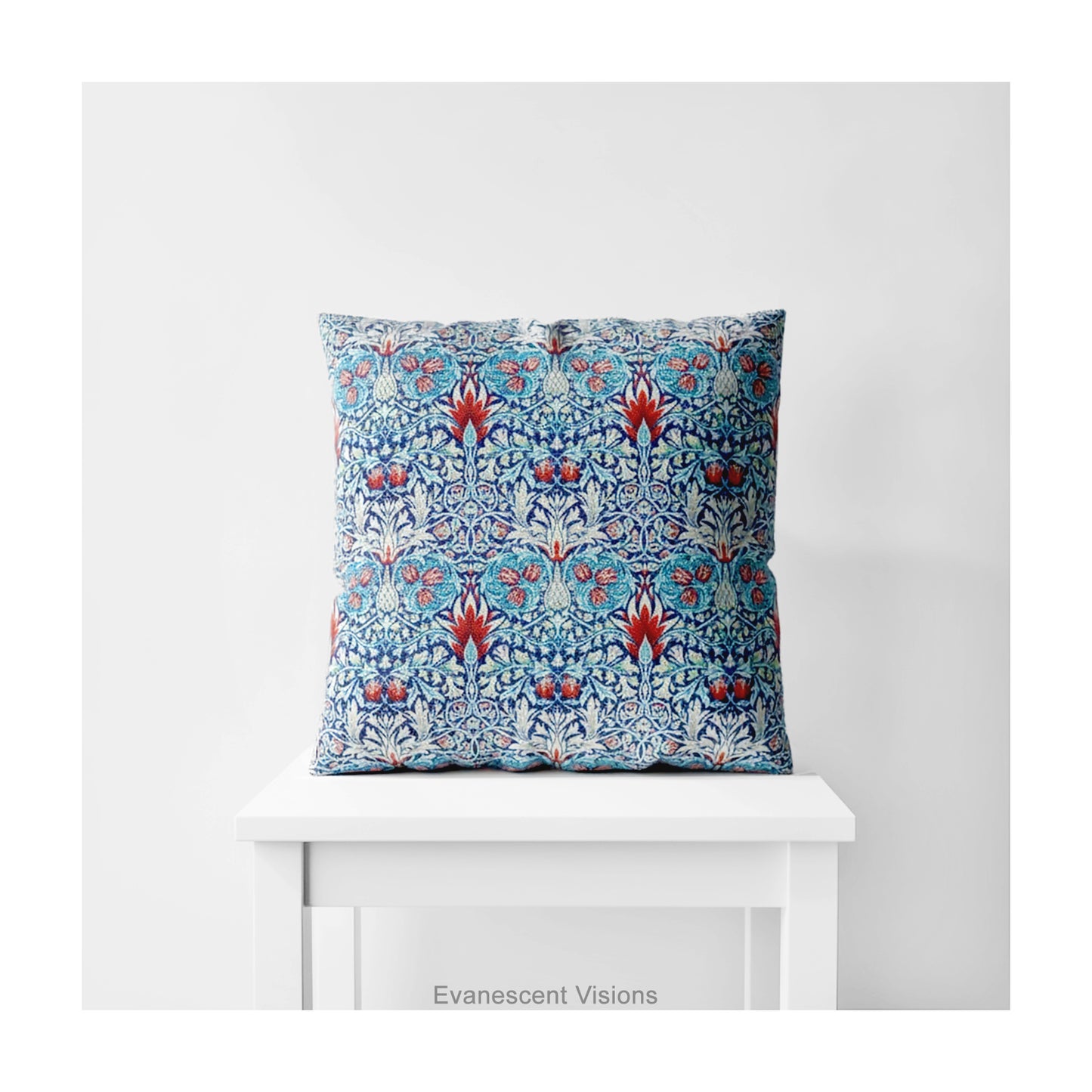 A square decorative cushion with red and blue floral themed pattern entitled 'Snakeshead' by William Morris, on a white stool.