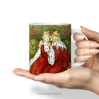 Hands holding a ceramic mug with painting of medieval lovers Aucassin and Nicolette by Amelia Bauerle.