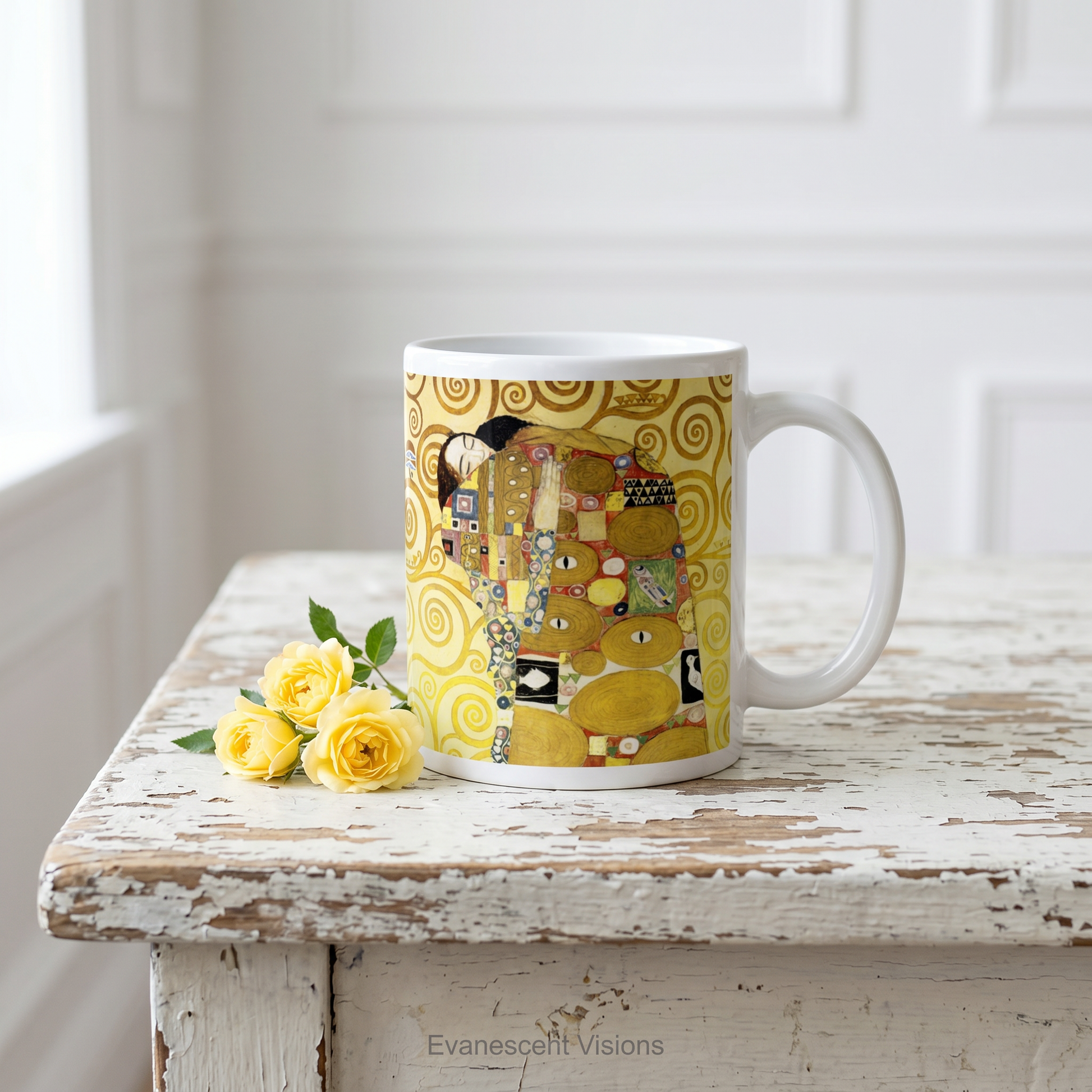 A white ceramic mug featuring Gustav Klimt's 'The Embrace' artwork, shown standing on a white wood table with small yellow roses. 