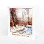 Winter Road Season's Greetings Traditional Christmas Card with artwork  'The Road to Ørholm' by Sigvard Hansen, with the card standing on a table.