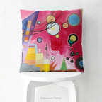 A colourful square cushion on a stool featuring an abstract art print of Schweres Rot (Heavy Red) by abstract artist Wassily Kandinsky.