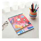 A hardcover notebook with a cover featuring  a colorful abstract geometric design titled 'Schweres Rot' by Kandinsky, shown on a desk with desk clutter.