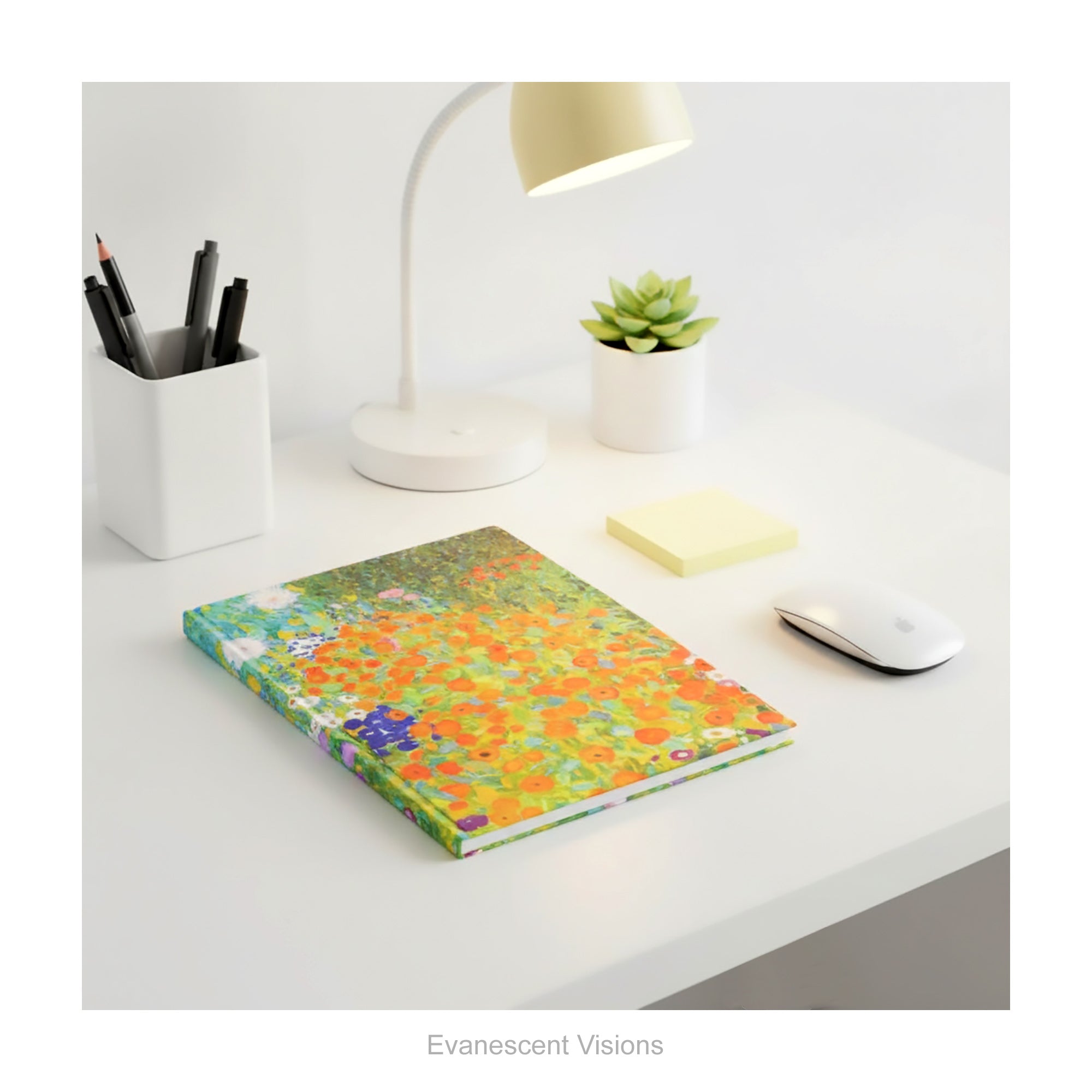A hardback notebook featuring the colourful impressionistic floral artwork 'Bauerngarten' by Gustav Klimt, shown lying on a white desk with desk accessories.