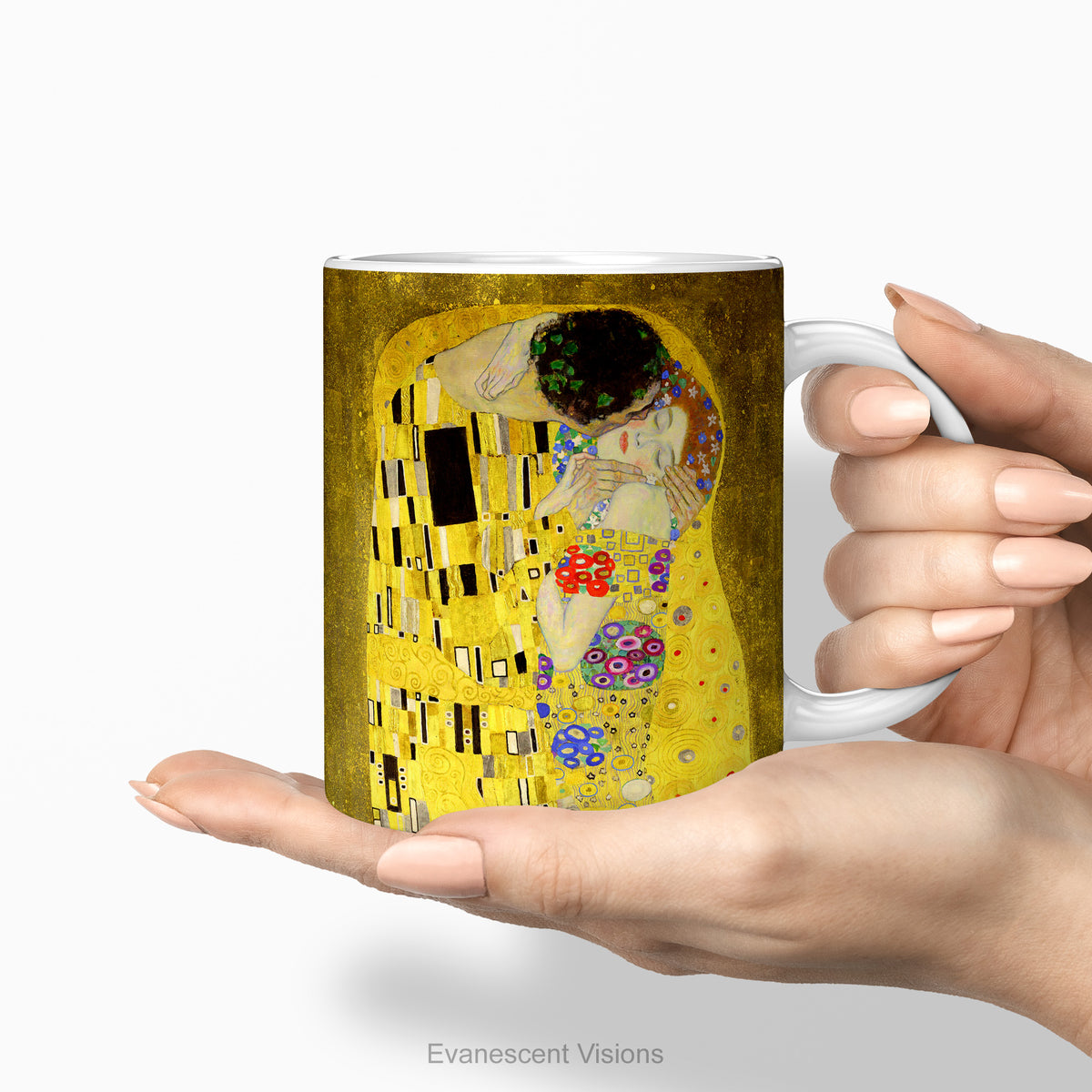 Hands holding a ceramic mug featuring a print of  Gustav Klimt's painting 'The Kiss'. 