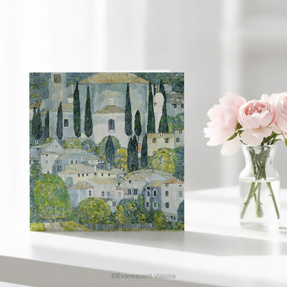 A square art greeting card on a table  featuring Gustav Klimt impressionistic painting 'Church at Cassone' a village scene with white buildings, green trees, and blue-gray sky.