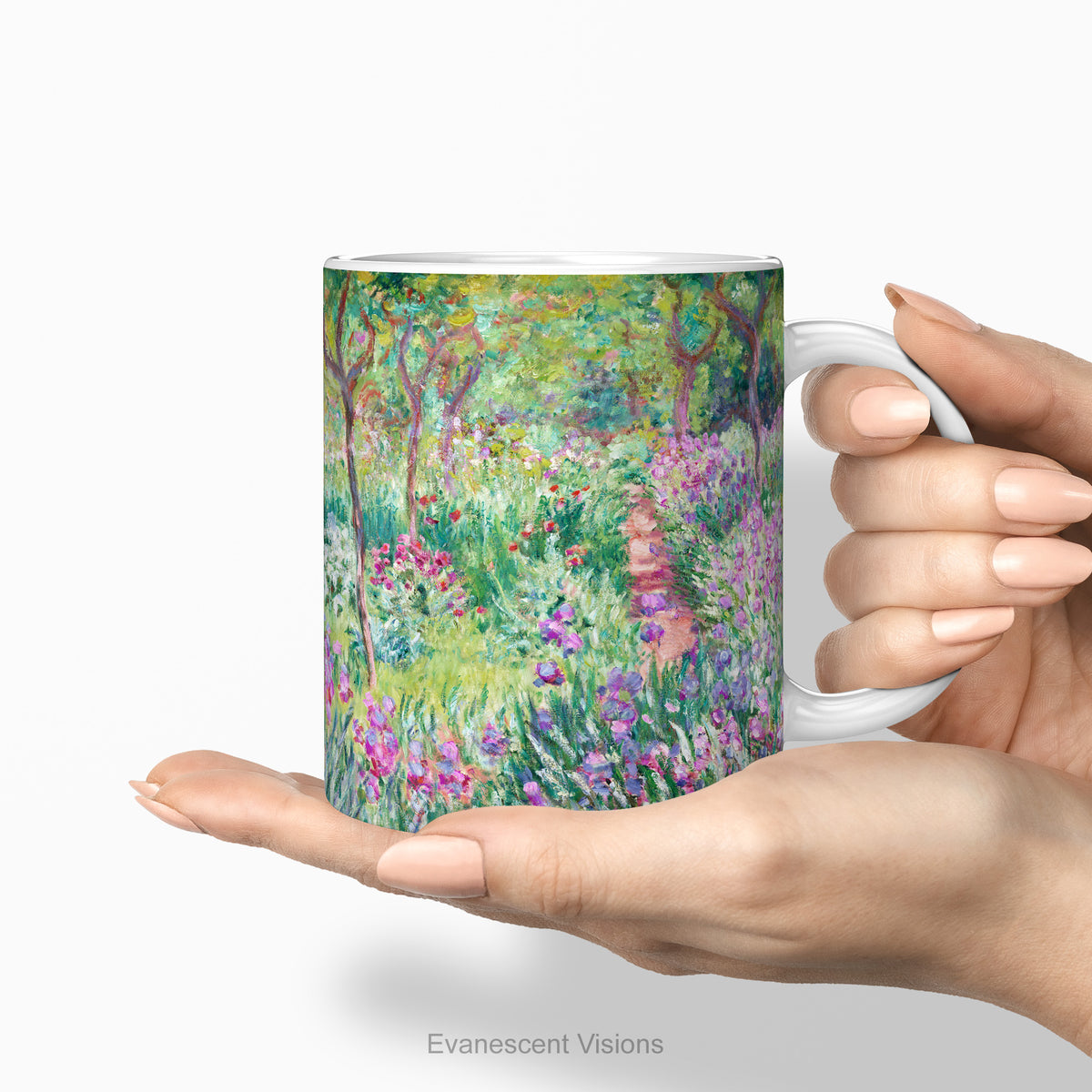 Hands holding a ceramic mug with a print of artwork The Artist's Garden at Giverney' by Claude Monet