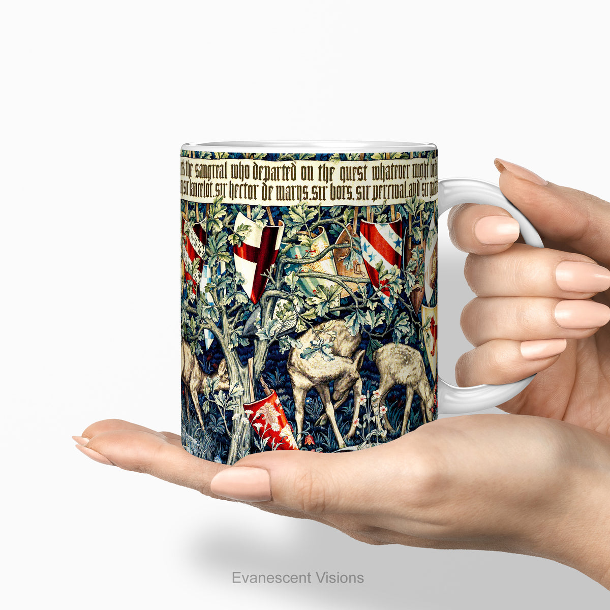 Hands holding a ceramic mug with a print of tapestry design 'Verdure with Shields and Deer'.