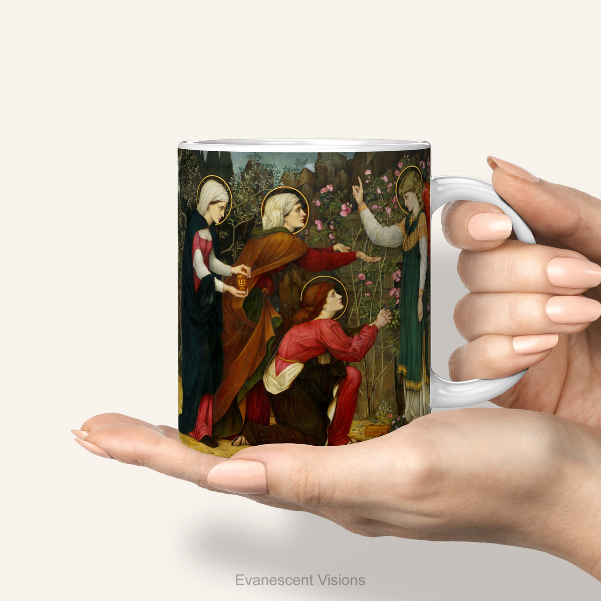 Hands holding a ceramic mug with artwork depicting the Three Mary's with an Angel.