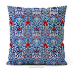 A square  cushion featuring  intricate William Morris pattern Snakeshead,  in blue, red, and white, 