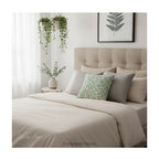 A square decorative cushion with green botanical pattern titled 'Willow Bough' by William Morris, shown styled on a bed in neutral tones. 