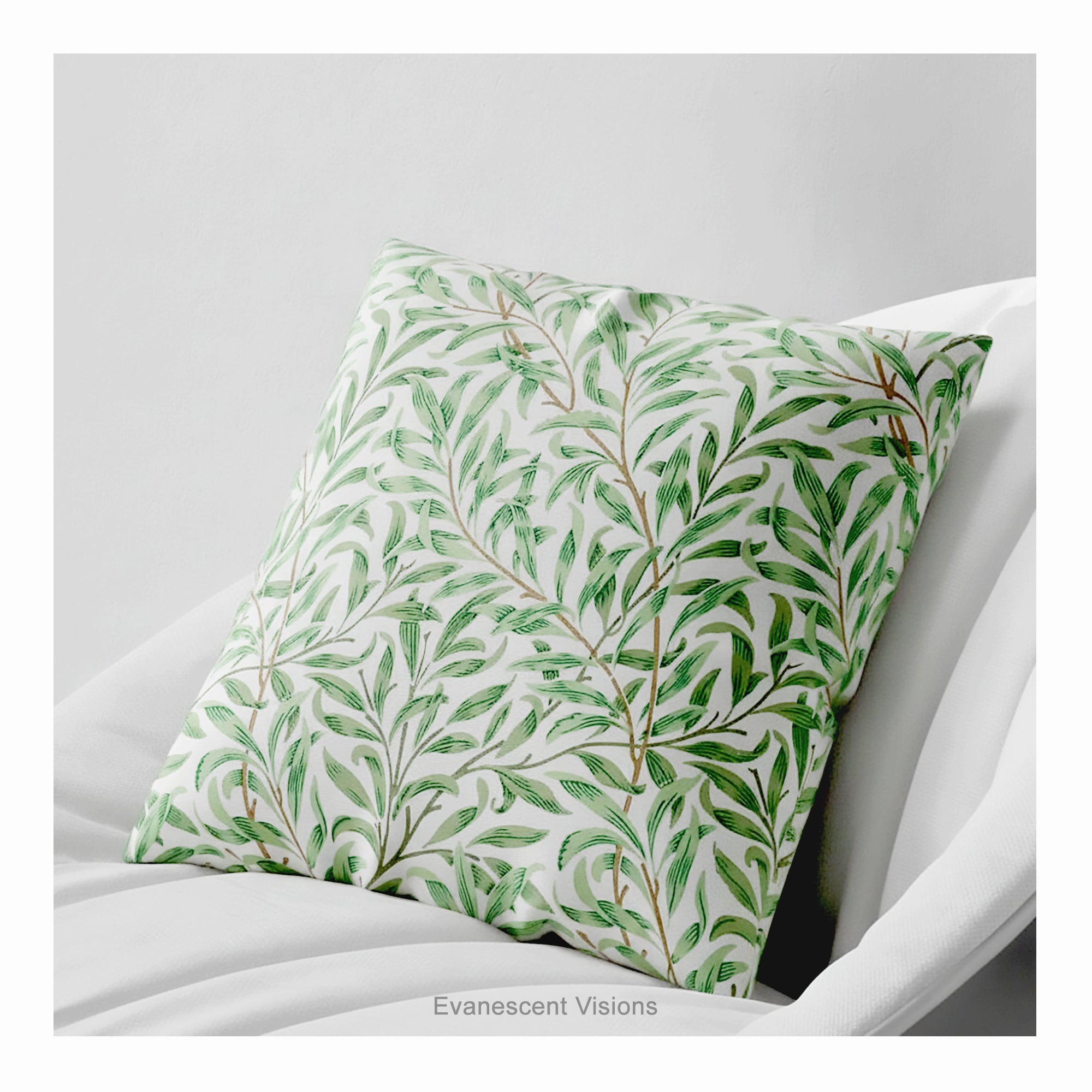 A square decorative cushion with green botanical pattern titled 'Willow Bough' by William Morris, on a white chair. 