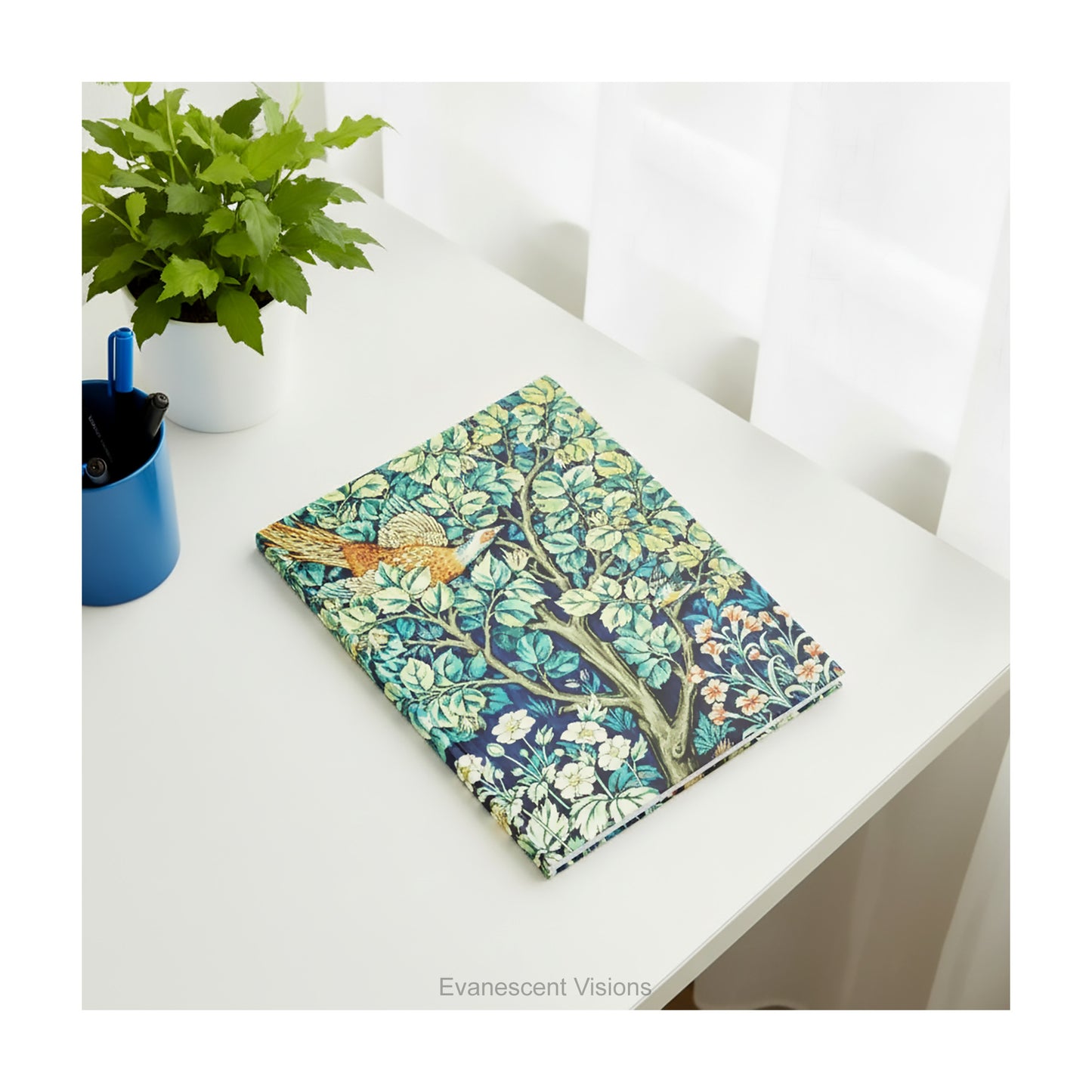 A Hardback with  William Morris textile design Cock Pheasant without the personalised band option, shown on a white table with a small plant.