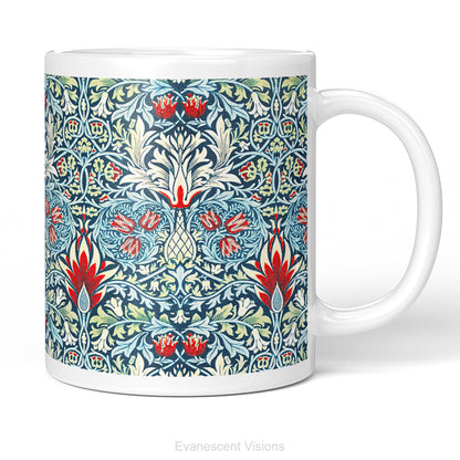 A white ceramic mug featuring a detailed, symmetrical floral pattern in navy blue, sage green, and red called Sankeshead by William Morris,   shown on a clean white background .