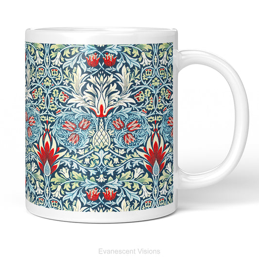 A white ceramic mug featuring a detailed, symmetrical floral pattern in navy blue, sage green, and red called Sankeshead by William Morris,   shown on a clean white background .