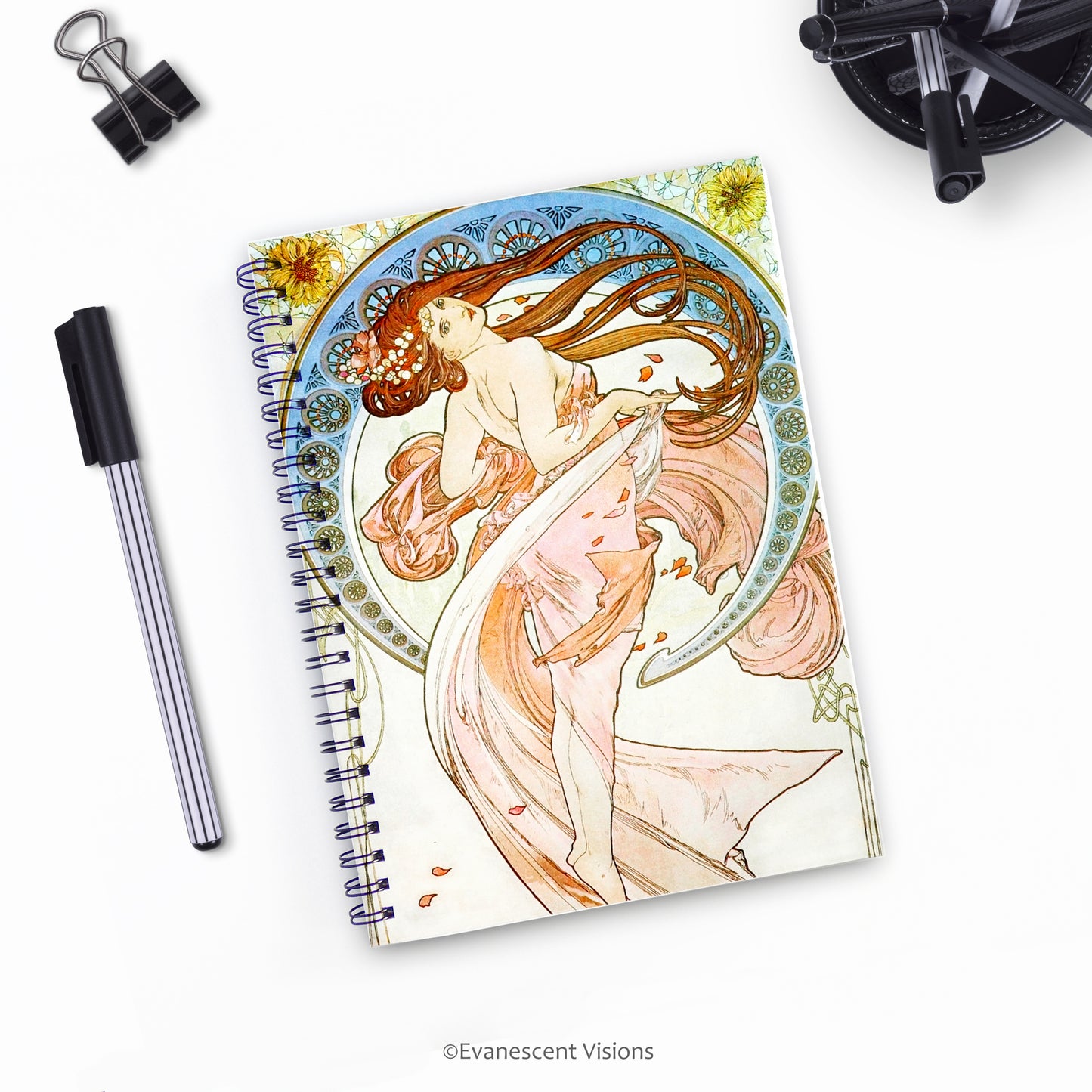 top down view of Mucha Dance Art Nouveau Style Spiral Bound Notebook with pens on a desk